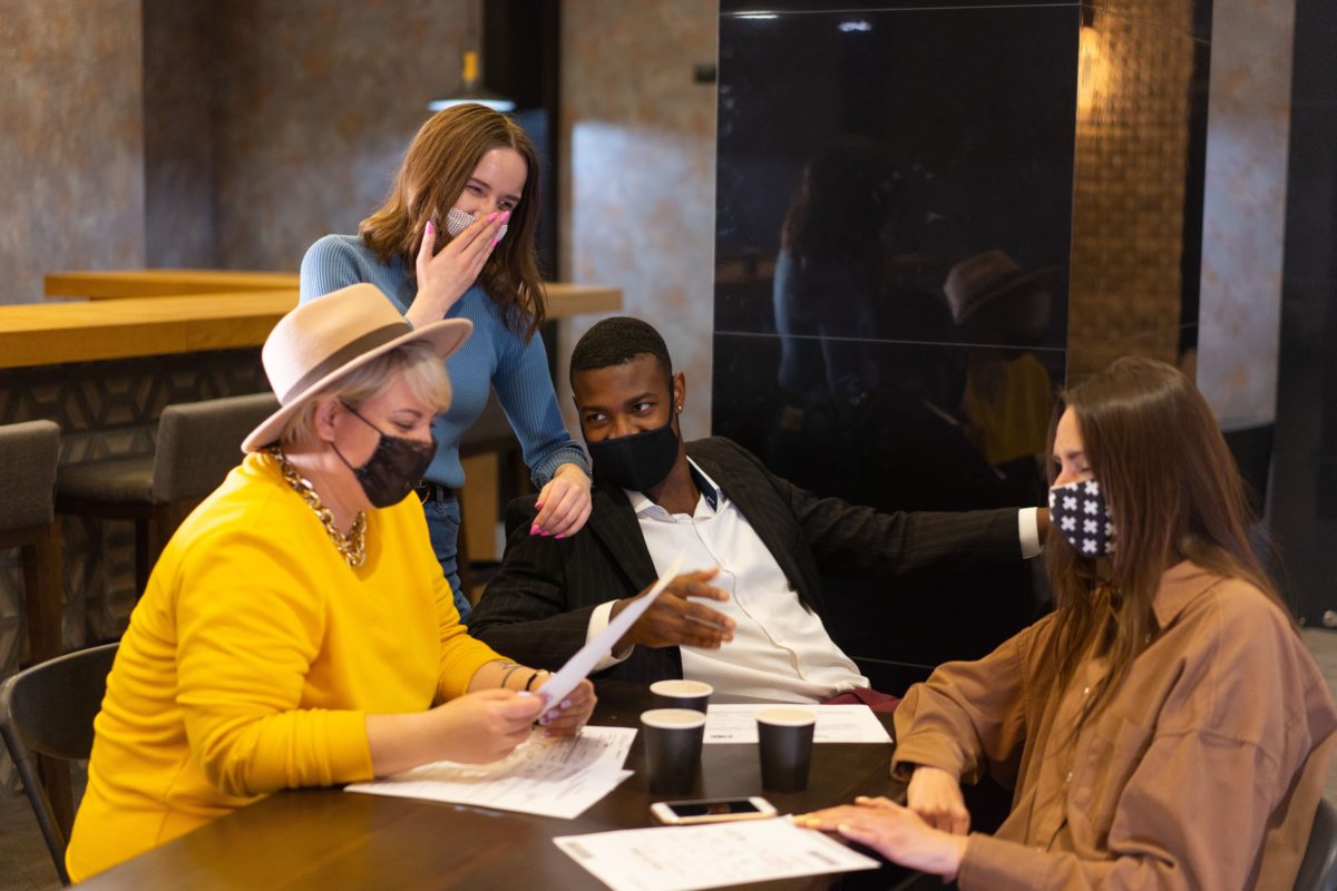 groupe de salariés qui portent le masque et font une réunion au bureau en 2022