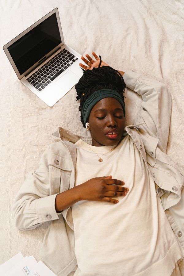 Femme qui dort avec son ordinateur à côté d'elle