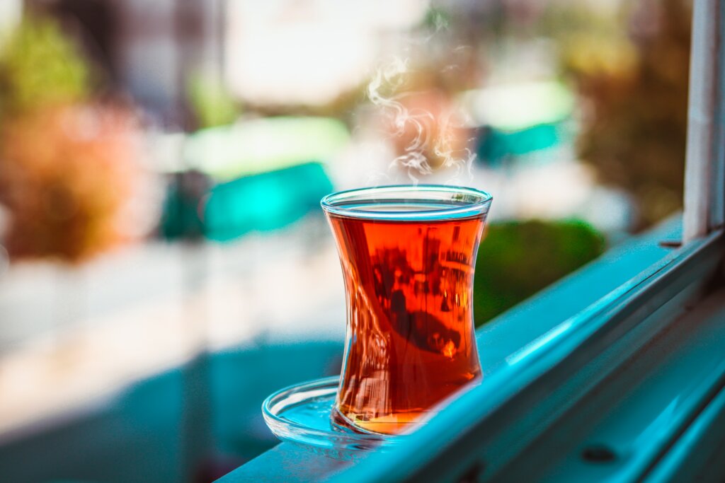 Un verre de thé fumant, posé sur le rebord d'une fenêtre