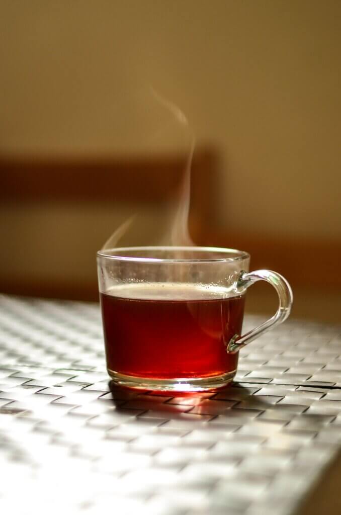 une tasse de thé fumante posé sur une table