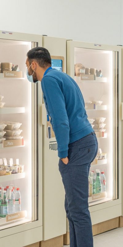salarié homme debout devant une frigo cantine conencté écologique Foodles